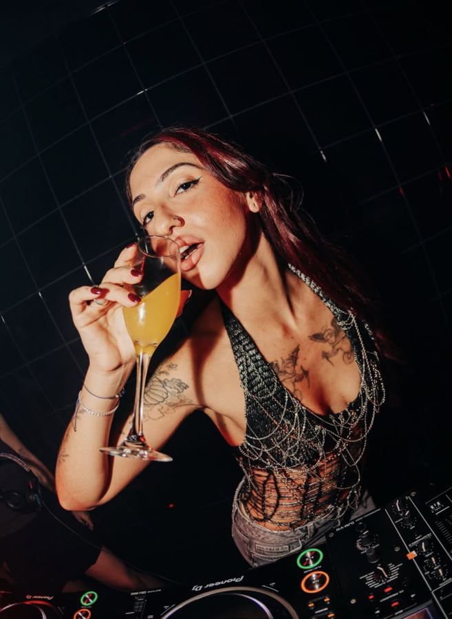 Woman drinking cocktail at the DJ booth