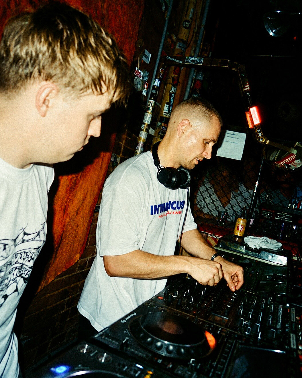 DJ duo close up, red brick wall