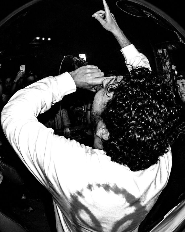 MC on the mic, crowd-surfing energy, b&w fisheye