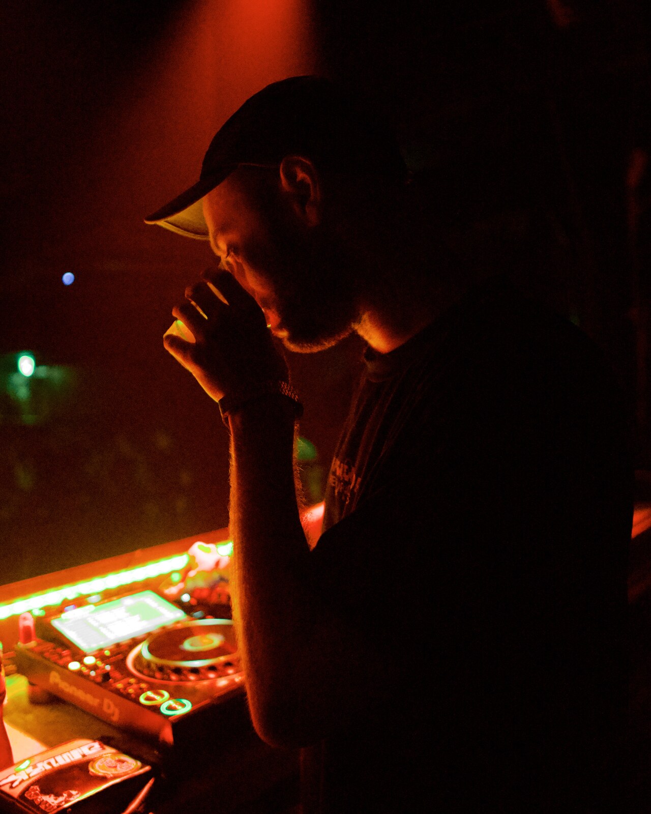 DJ silhouette, red light, hands clasped