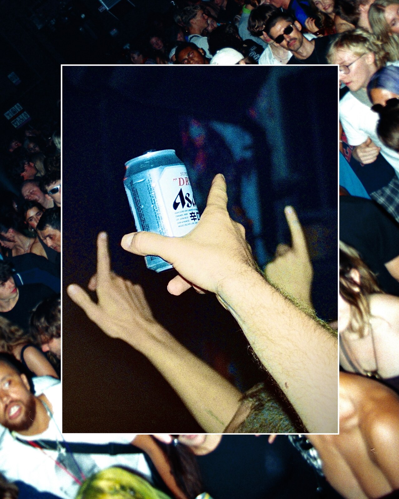 Hands raised holding a drink can, crowd film photo
