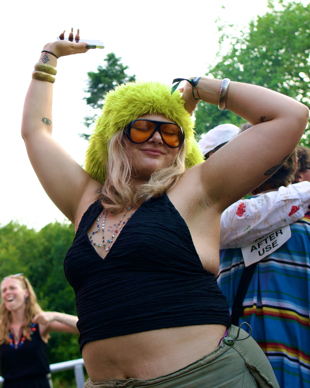 Woman dancing in furry hat and orange sunglasses